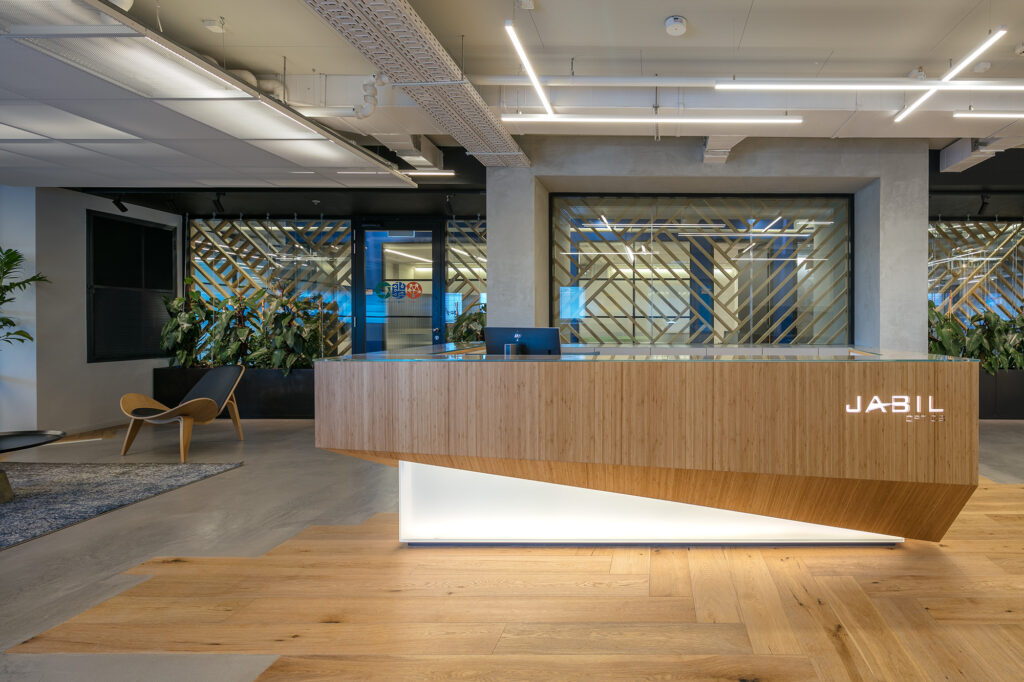 Reception lobby with timber counter and slatted screen at the Jabil Optics facility