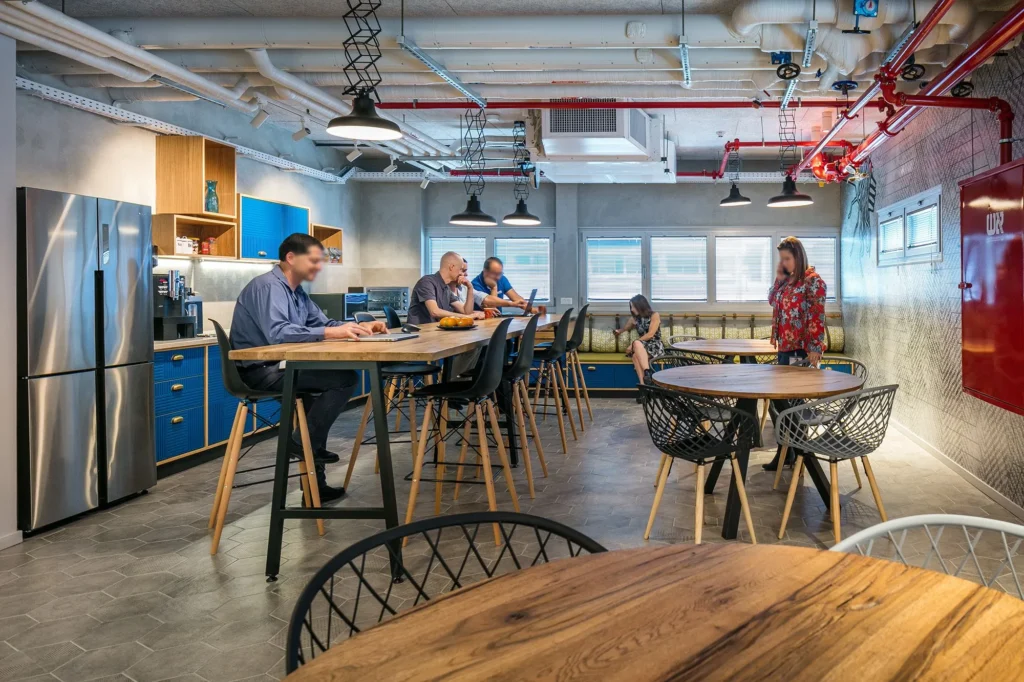 Staff kitchenette with high stools and pendant lighting at the Jabil Optics facility