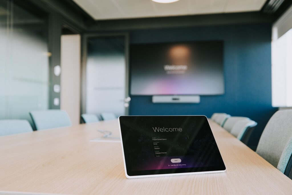 Meeting room with a wall screen and a room booking panel at the IBM offices