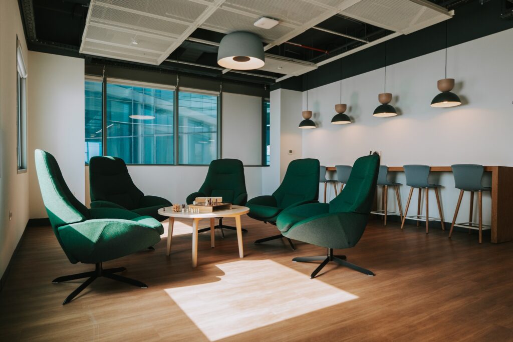 Meeting room with green armchairs and pendant lighting in a Domark office project