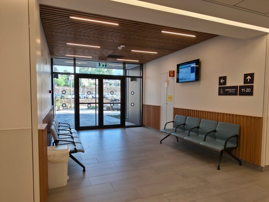 Clinic waiting area with a wood-slat ceiling at Beit Shulamit