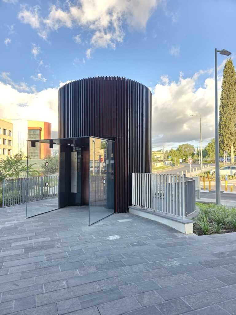 Cylindrical elevator pavilion at the entrance plaza of Beit Shulamit