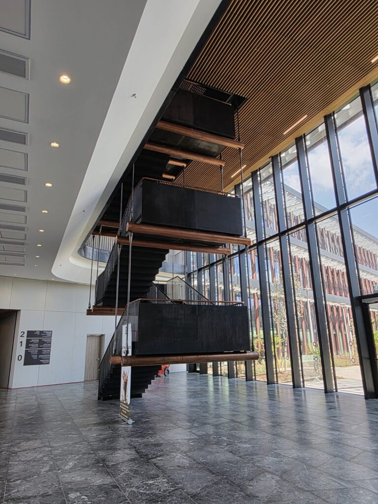Suspended staircase in the glazed lobby of Beit Shulamit