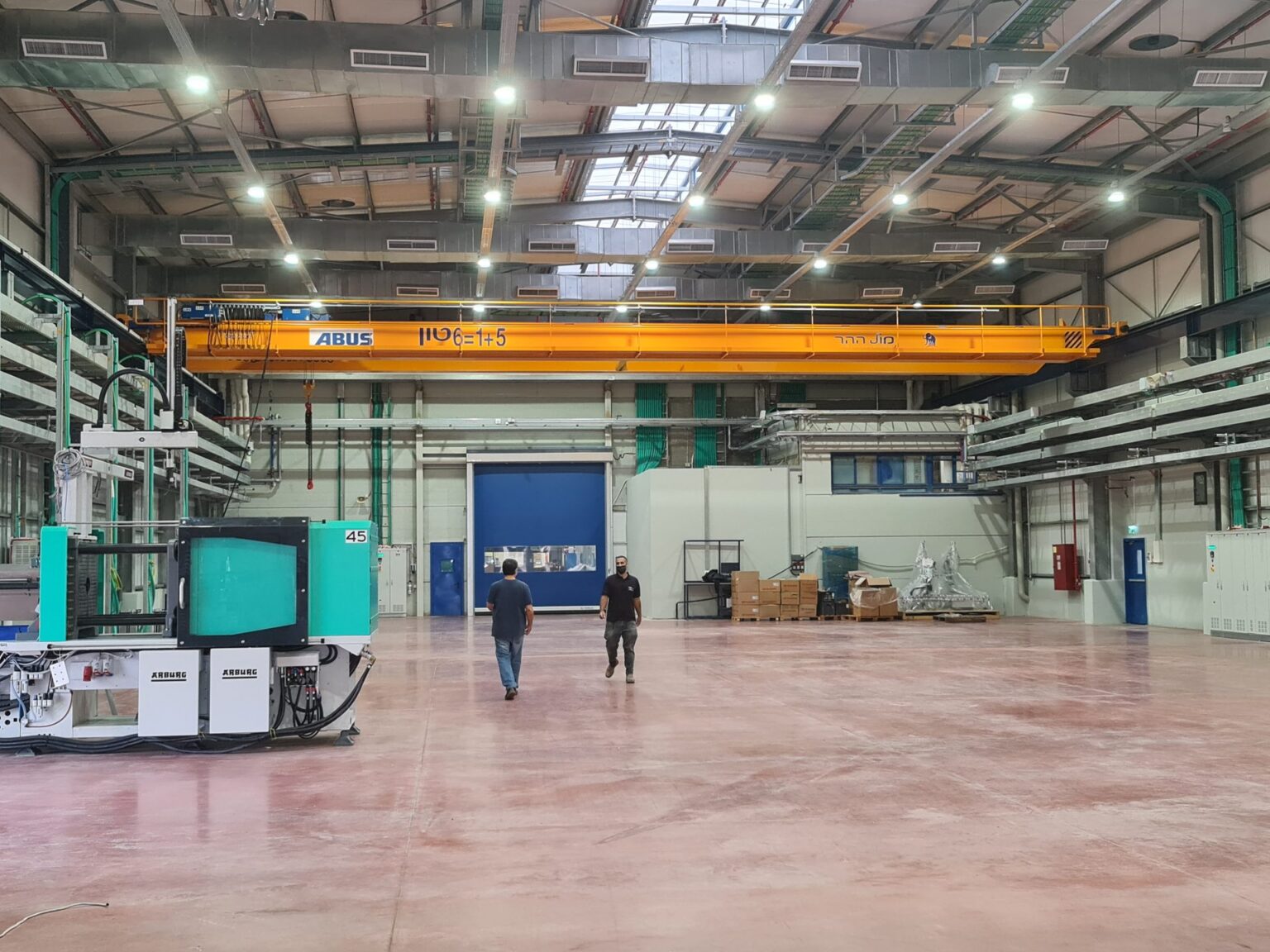 Two people walking through the finished production hall of the Bermad Assembly Plant