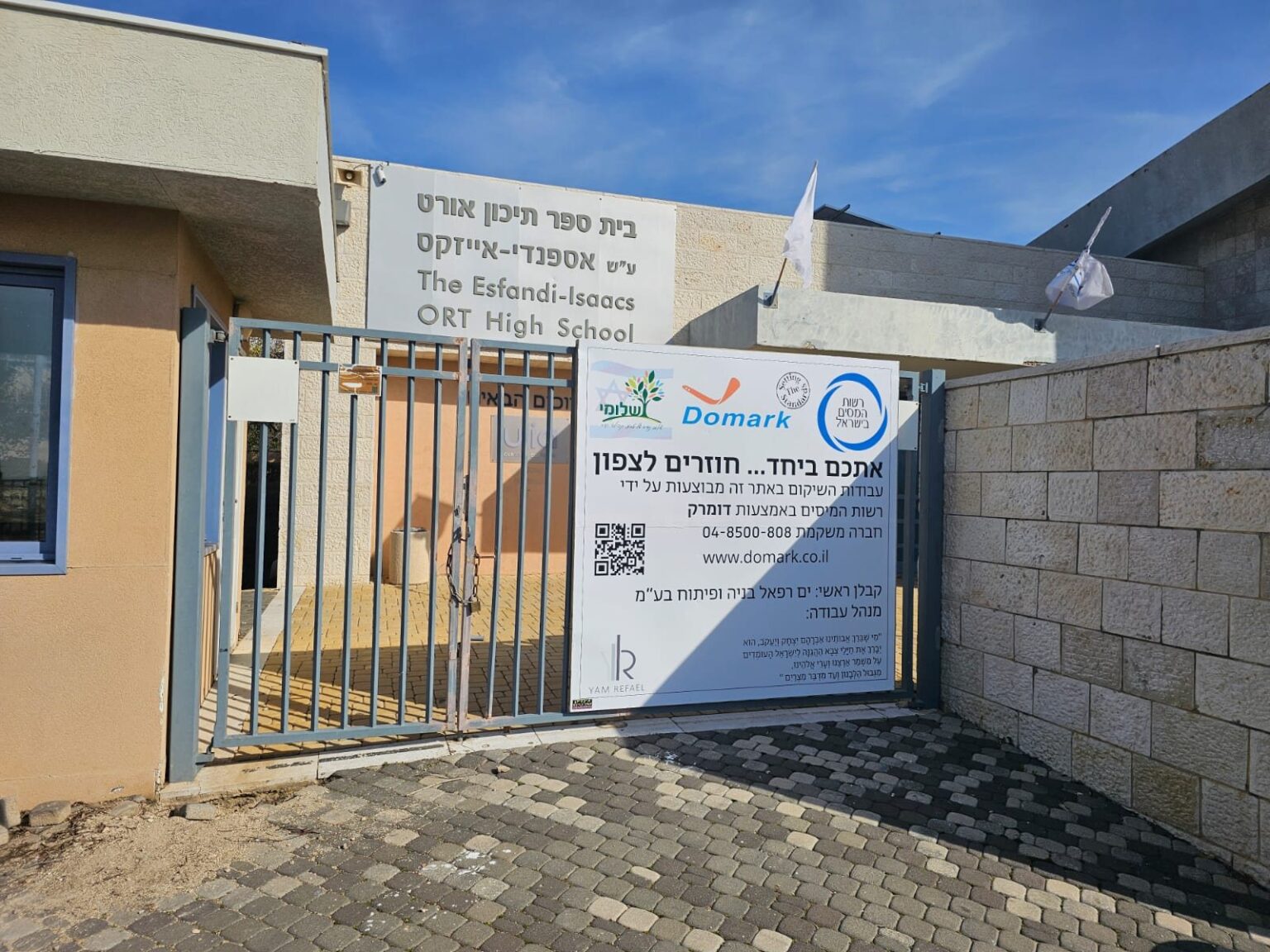 Site sign at a school gate with the logos of Domark and the Israel Tax Authority