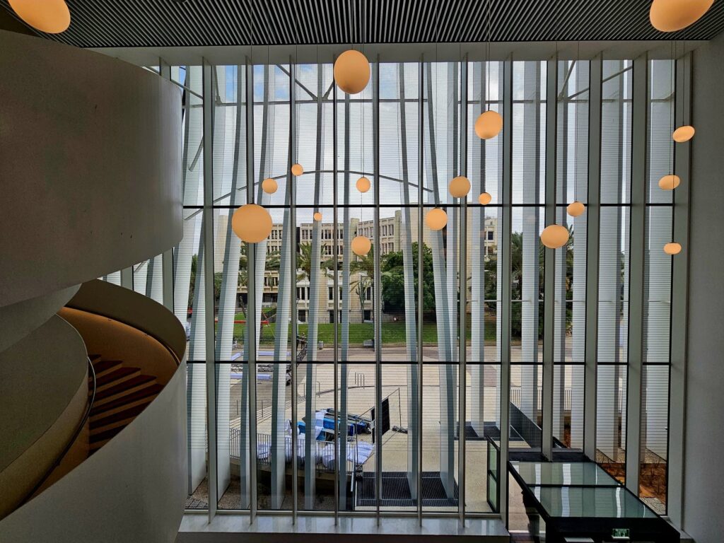 Atrium with pendant globe lights and a full-height glazed facade at the TAU Nanotechnology Center